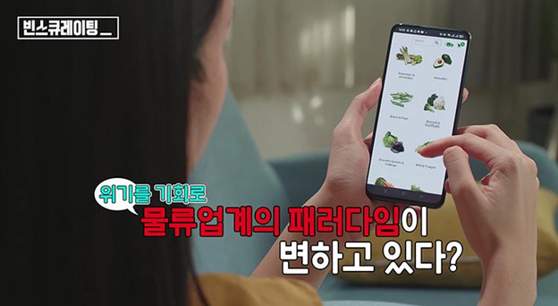 A woman shops for vegetables on her phone through an e-commerce platform in which customers can get groceries delivered at home.