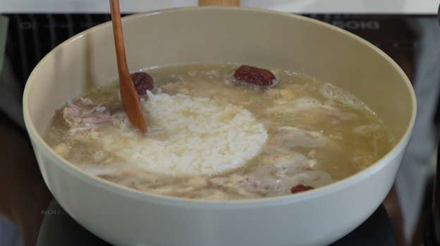 image of Samgyetang broth and rice being cooked in a large bowl 