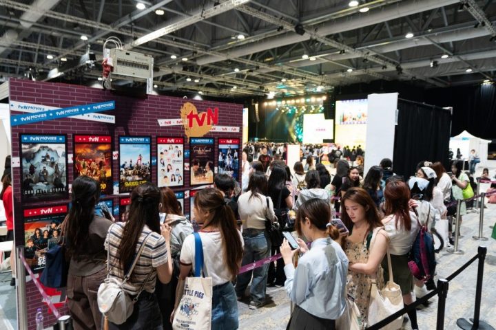 Photo with line of fans browsing Korean content such as tvN dramas at the convention booth.
