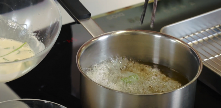 Pan filled with hot oil on the right, bowl with cilantro, flour and water on the left. 

