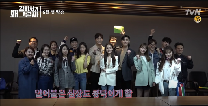 group photo of Koreans studio workers holding there fists up