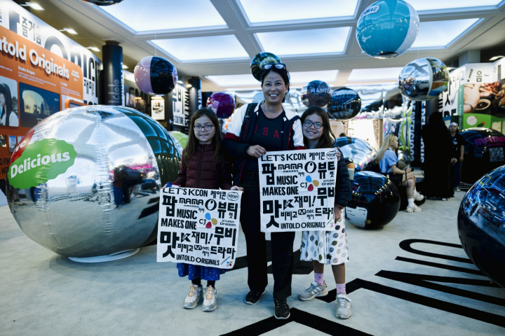 Visitors hold up posters for a photo at the CJ Group Hall

