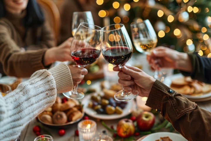 A Group Of Friends Toasting With Wine Glasses At The Dining Table, Surrounded By Food And Decorations 