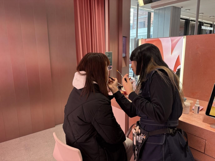 A makeup artist at Olive Young N Seongsu applies beauty products for a hands-on K-beauty experience.