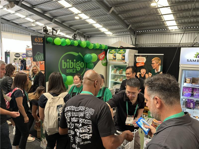 At the Foodstuffs Expo, New Zealand’s largest B2B food trade show, visitors wait in line at a bibigo stand while employees assist them.