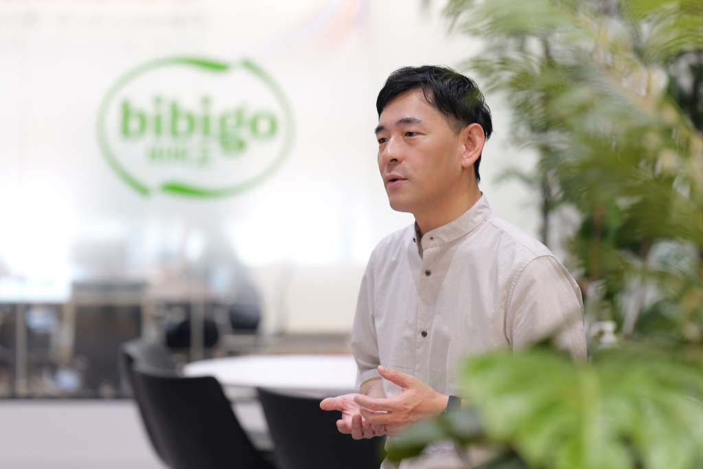 CJ Foods employee doing a interview with the bibigo logo in the background