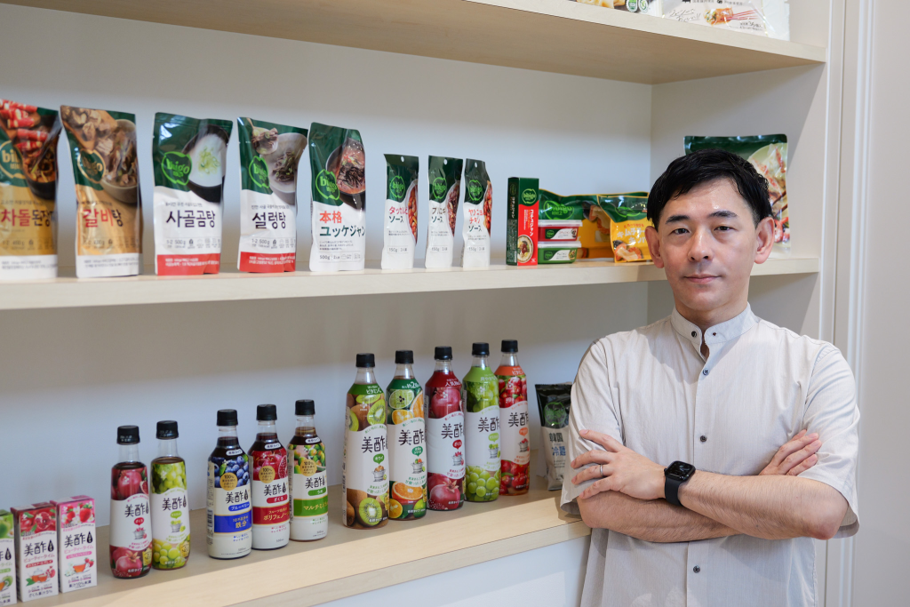 CJ Foods' employee next to bibigo and Micho products