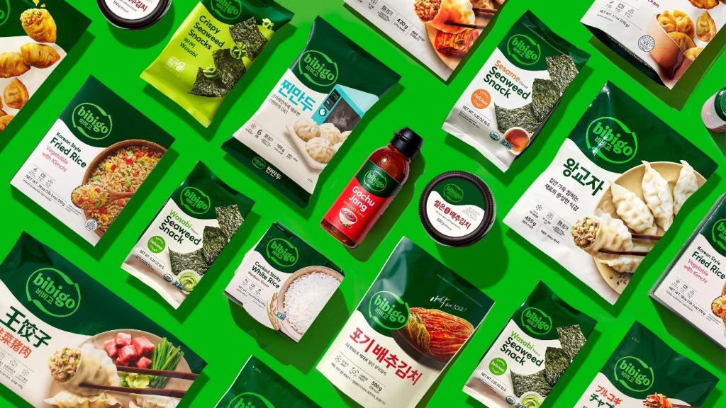A variety of globally available bibigo products behind a green background with bibigo Gochujang at the center 