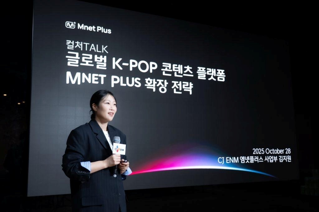 Kim Jiwon speaks at the CULTURE TALK event in front of a slide titled “Expanding Mnet Plus, a Global K-pop Content Platform.”