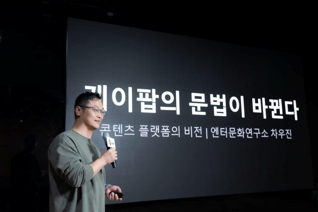 Cha Woojin speaks at the CULTURE TALK event in front of a slide titled “The Grammar of K-pop Is Transforming.”