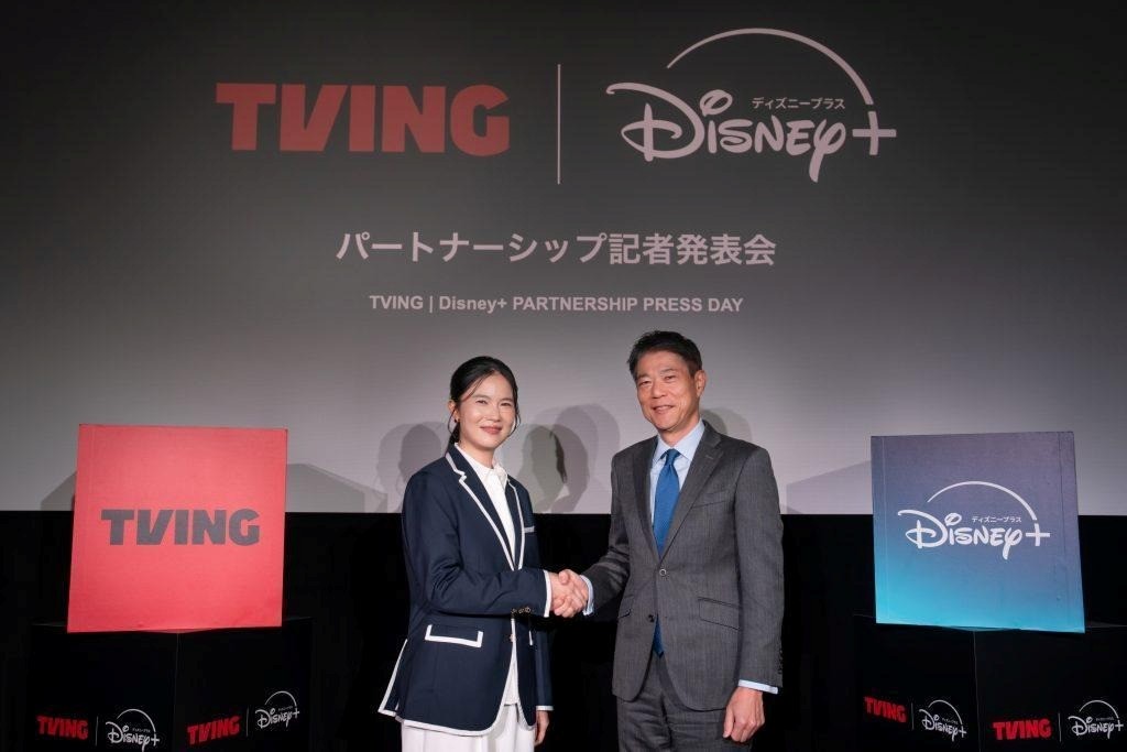 TVING CEO Julie Choi shakes hands with Walt Disney Company Japan President Tamotsu Hiiro.
