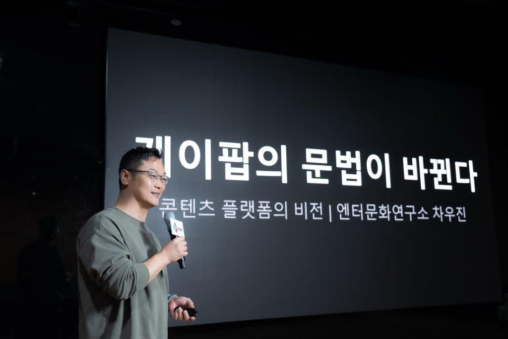 Cha Woojin speaks at the CULTURE TALK event in front of a slide titled “The Grammar of K-pop Is Transforming.”