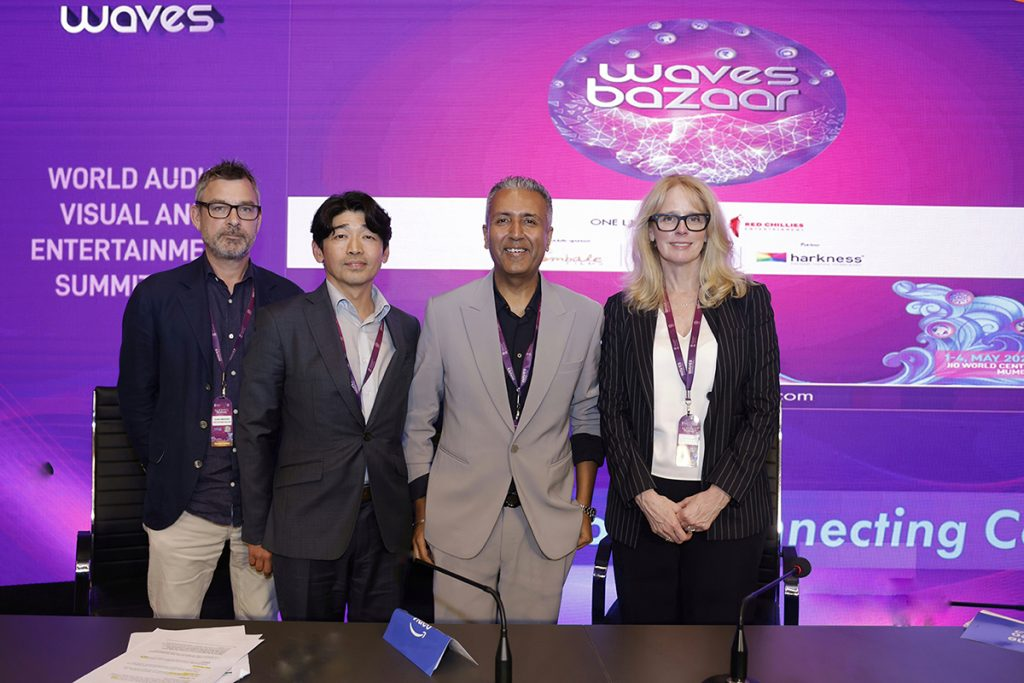 Executives from CJ ENM and Amazon, Seo Jang-ho, David Simonsen, Gaurav Gandhi and Kelly Day stand before a “waves bazaar” screen
