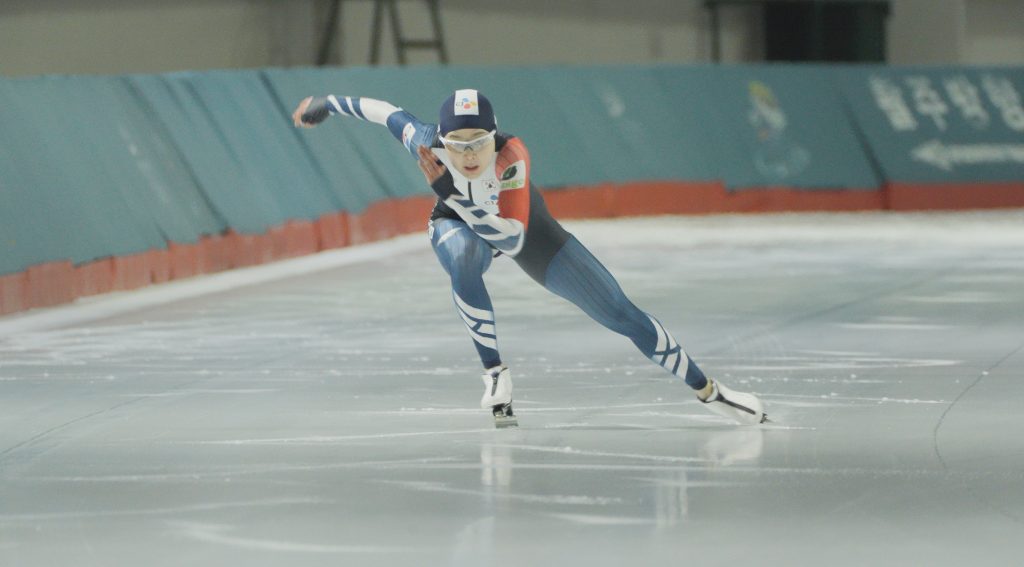 An action shot of Kim Min-sun speed skating on an ice rink.