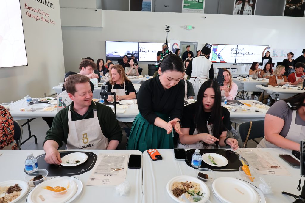 A Cuisine.K instructor teaches several participants at a cooking class