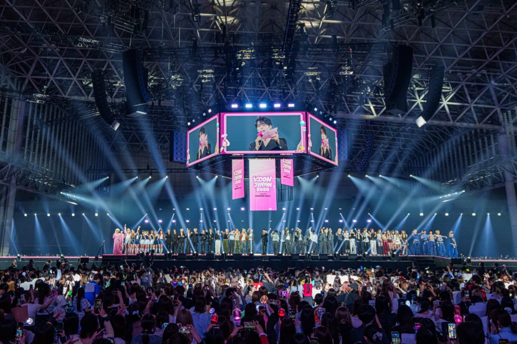 K-pop artists gather onstage before a packed audience during KCON JAPAN 2026 at Makuhari Messe in Chiba, Japan.