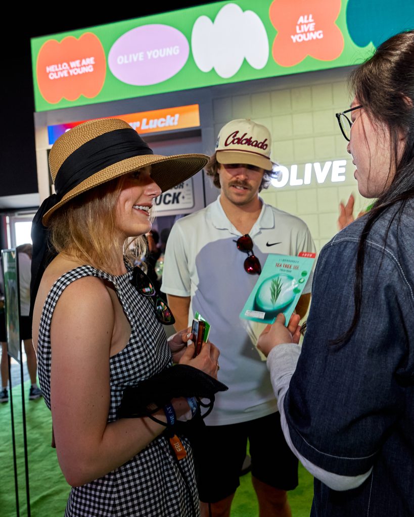 Visitors speak with staff at the OLIVE YOUNG booth during THE CJ CUP Byron Nelson.