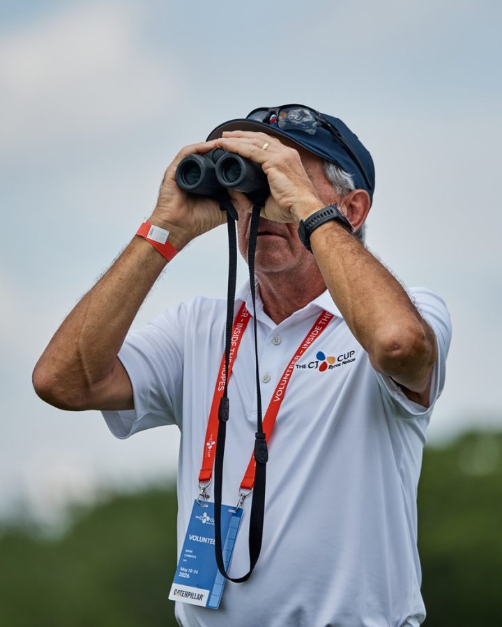 A volunteer looks across the course through binoculars at THE CJ CUP Byron Nelson.