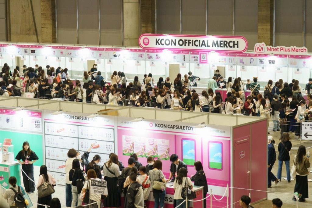 Visitors browse the KCON official merchandise and Mnet Plus Merch booths at KCON JAPAN 2026.