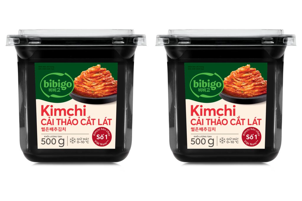 Two containers of bibigo Kimchi Cải Thảo Cắt Lát, a sliced cabbage kimchi product sold in Vietnam, displayed on a white background.