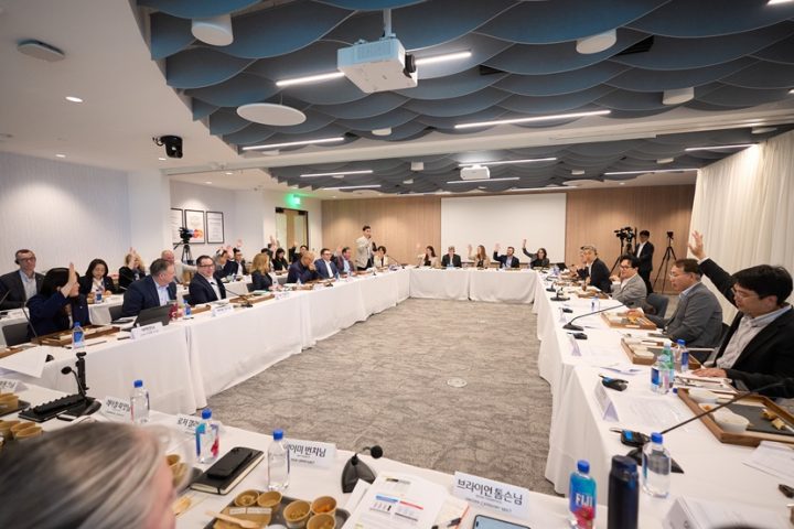 Chairman Lee and several CJ and Schwan’s executives sit around a large circular grouping of desks in a conference room.