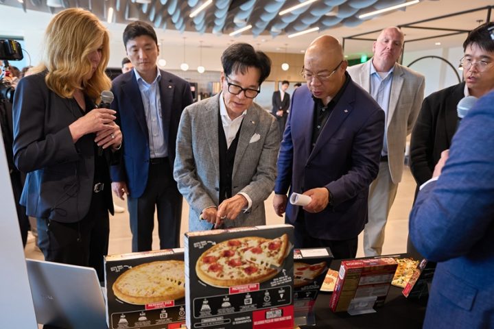 Chairman Lee and other CJ and Schwan’s executives look at several boxes of Red Baron’s Crunch Time frozen pizza.