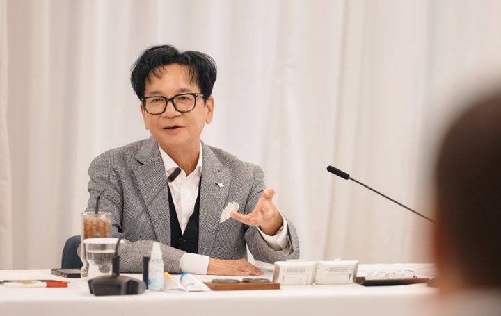 Chairman Lee speaks from the conference table against a white background.