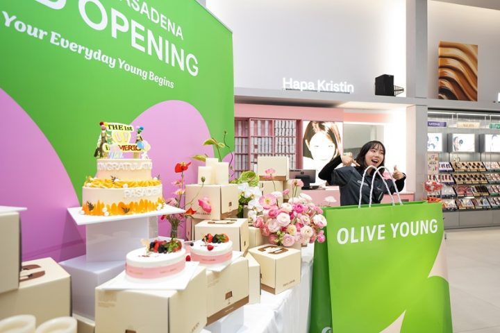 An employee poses with a TOUS les JOURS cake, a gift from Chairman Lee to mark the store opening.