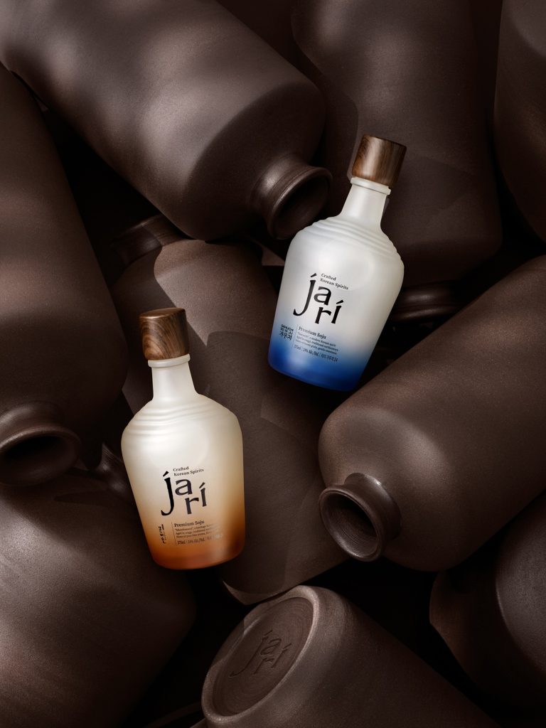 Two jari bottles are placed among traditional Korean earthenware pots.