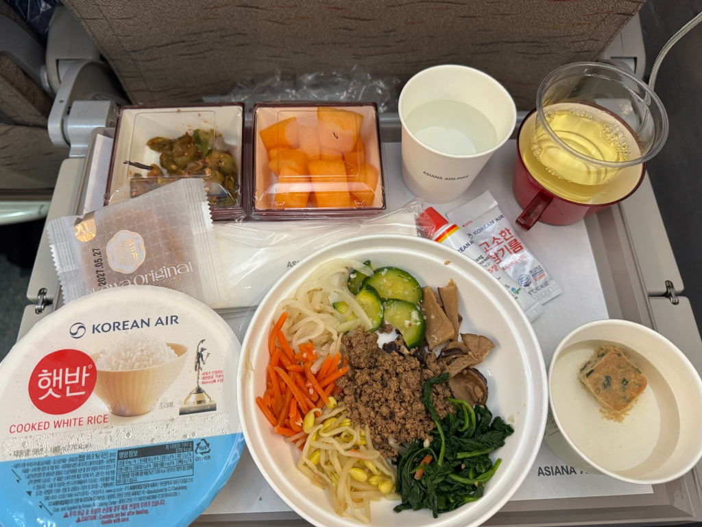An in-flight meal with bibimbap, featuring bibigo Cooked Sticky White Rice and Gochujang Sauce.