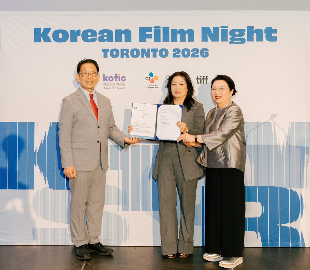 Han Sang-jun, Anita Lee and Heekyung Jo Min pose for a commemorative photo at TIFF in front of a banner for Korean Film Night. Photo courtesy of KOFIC)