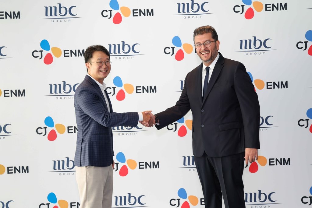 Sebastian Kim (left) of CJ ENM and Tareq Alibrahim of MBC GROUP shake hands after signing their strategic partnership.