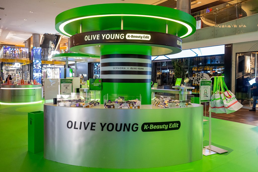 OLIVE YOUNG K-Beauty Edit pop-up in Singapore, featuring a green and silver display of Korean beauty products in partnership with Sephora.